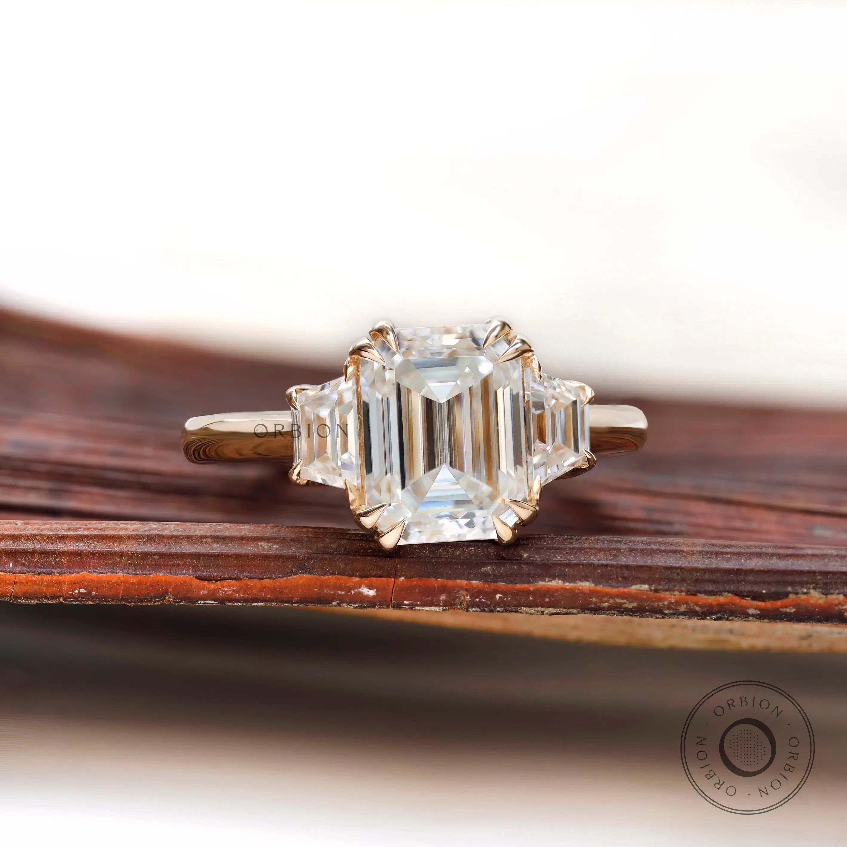 Three stone ring with trapezoid side stones in yellow gold