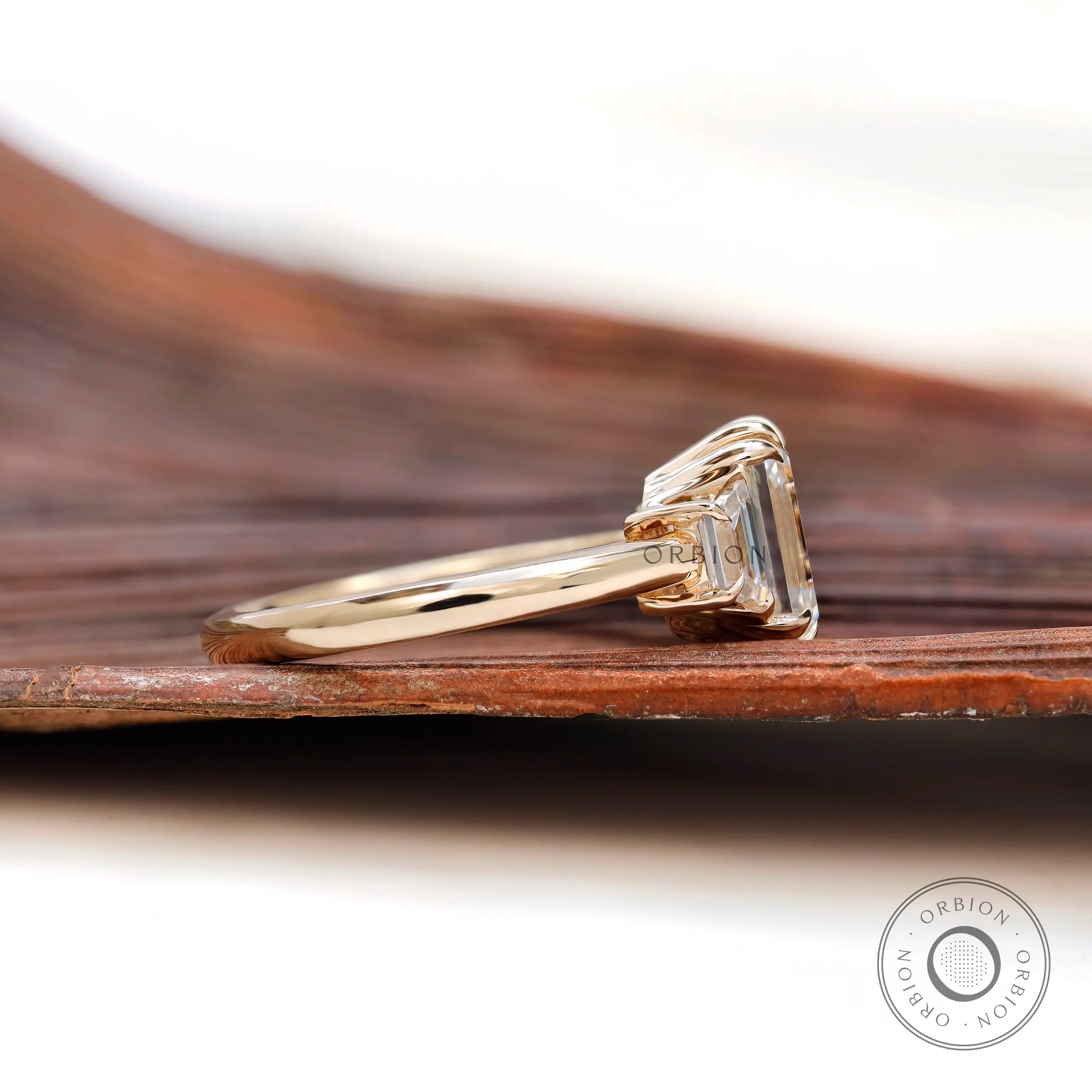 Side profile of three stone moissanite ring in 14K gold