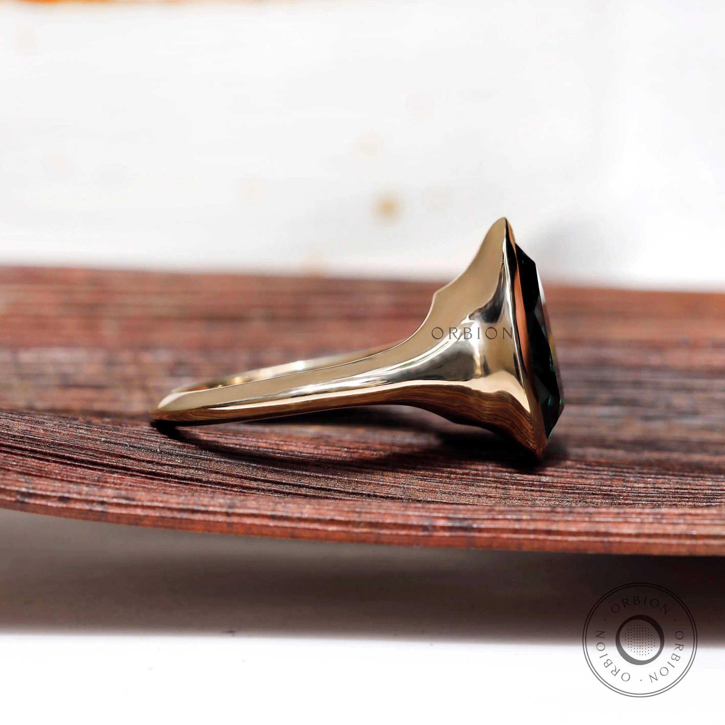Side profile of pear dark green moissanite bezel solitaire signet ring