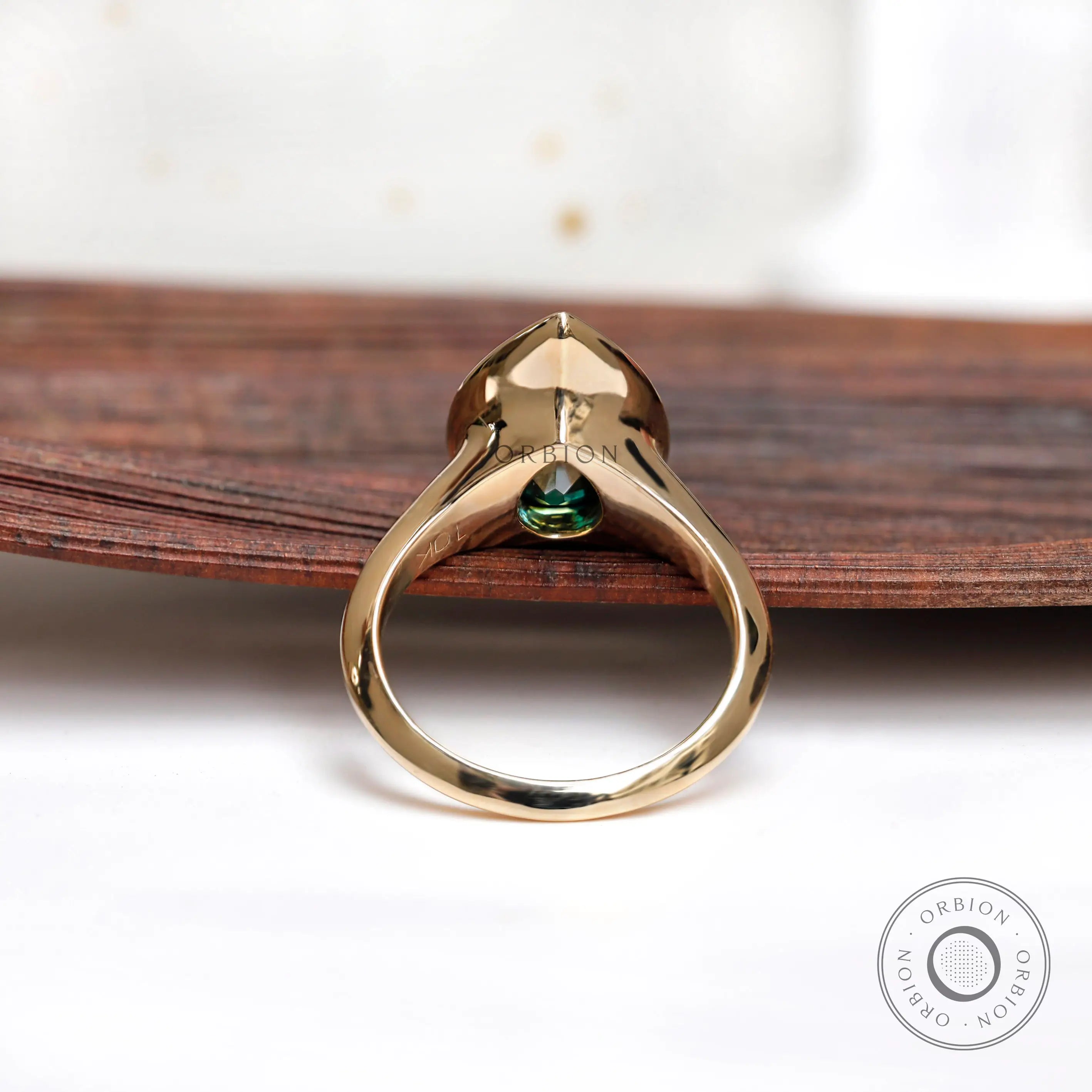 Back view of pear green moissanite signet ring showing sculptural gold band