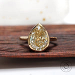 Pear old mine cut moissanite bezel set solitaire ring in yellow gold front view
