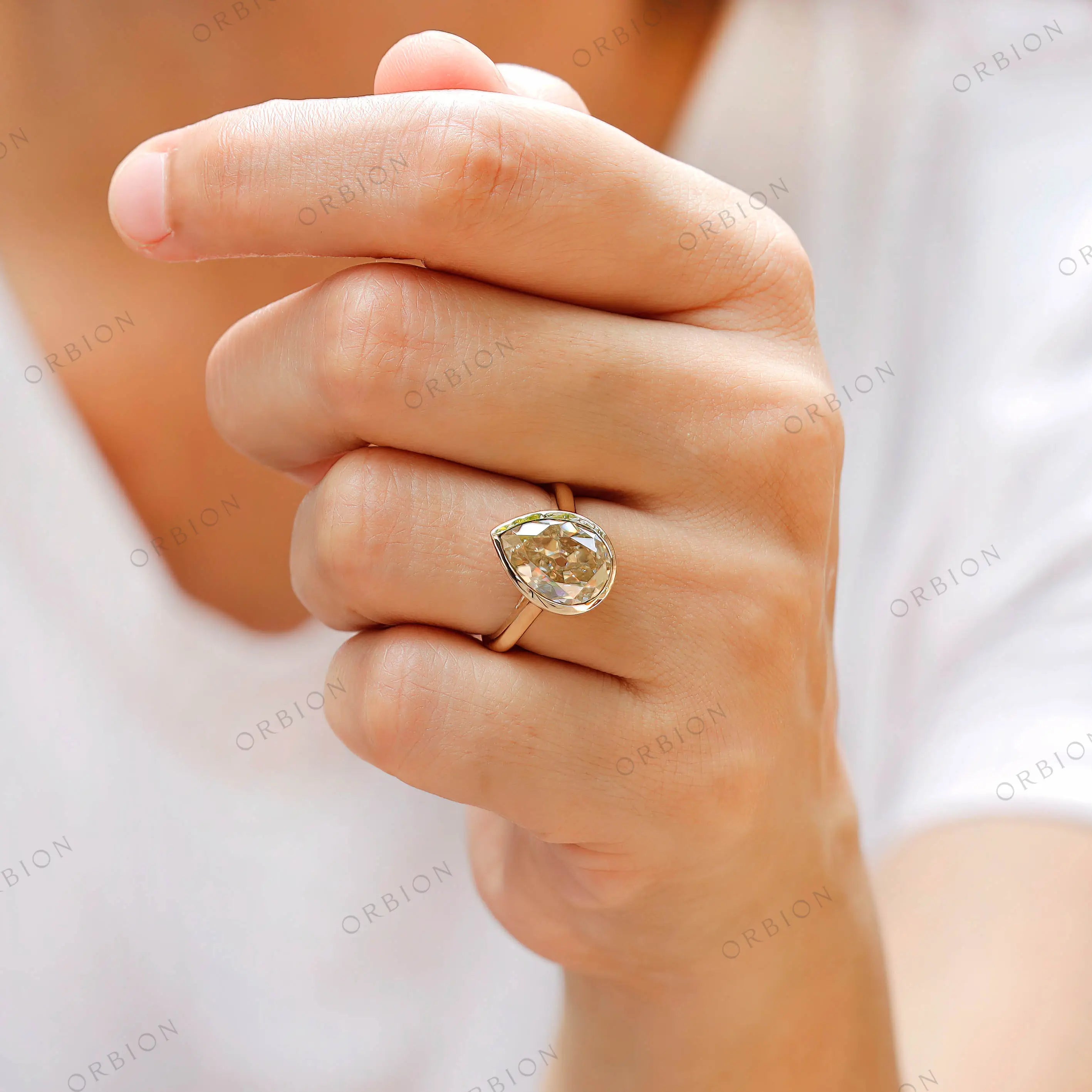 Detailed front view of pear moissanite in bezel setting