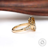 Side angle of pear moissanite ring with pave band detail