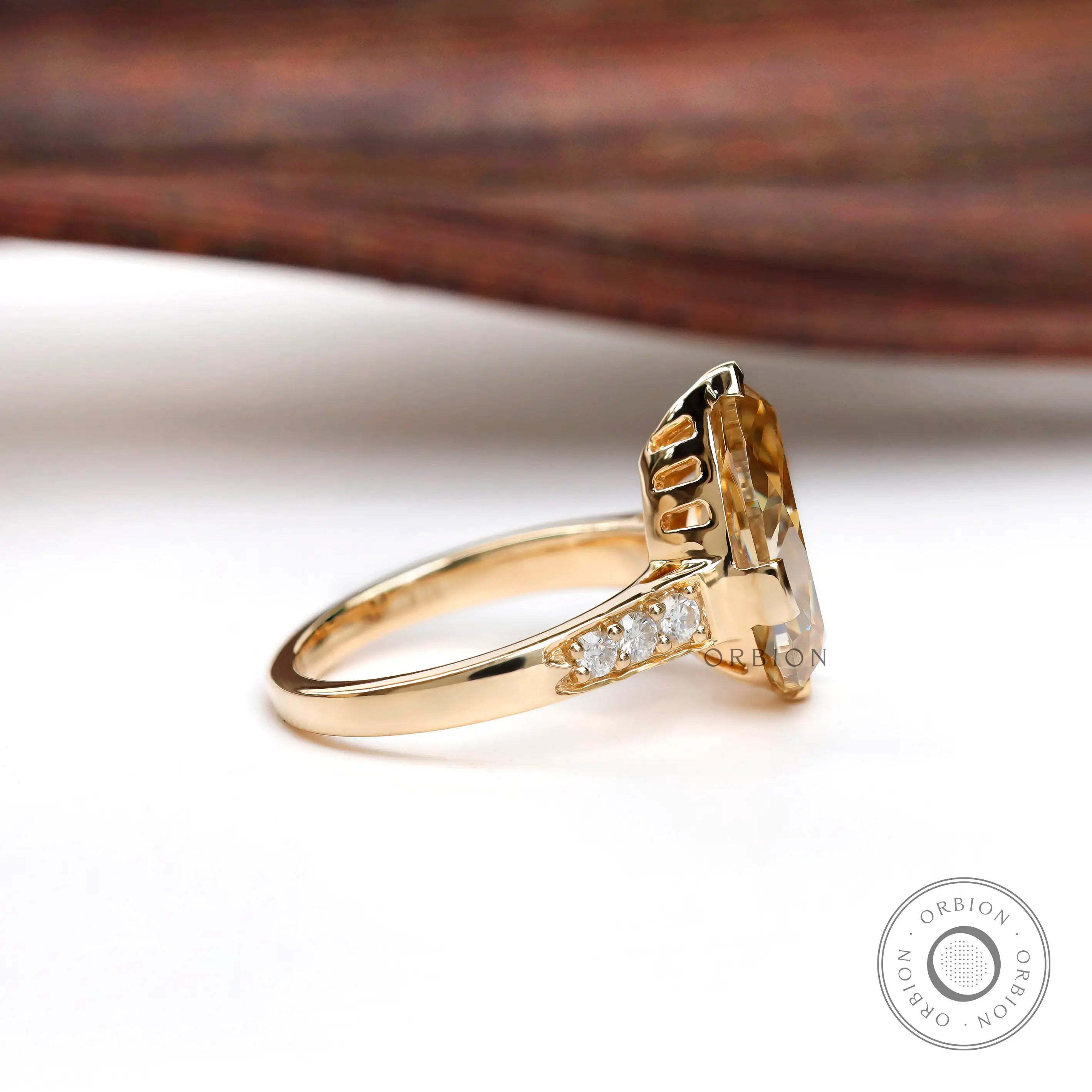 Side angle of pear moissanite ring with pave band detail