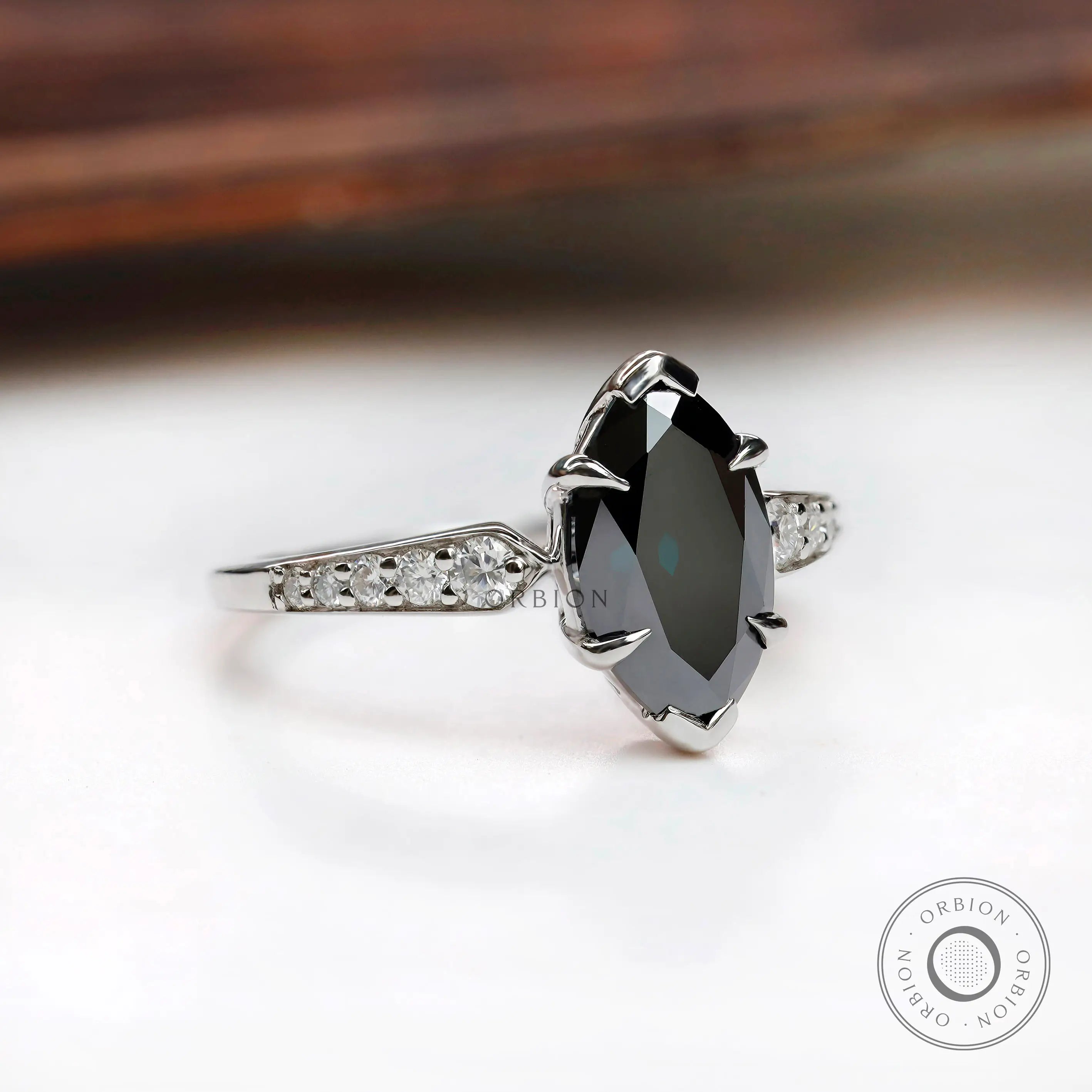 Front centered view of deep green marquise moissanite ring with round side stones