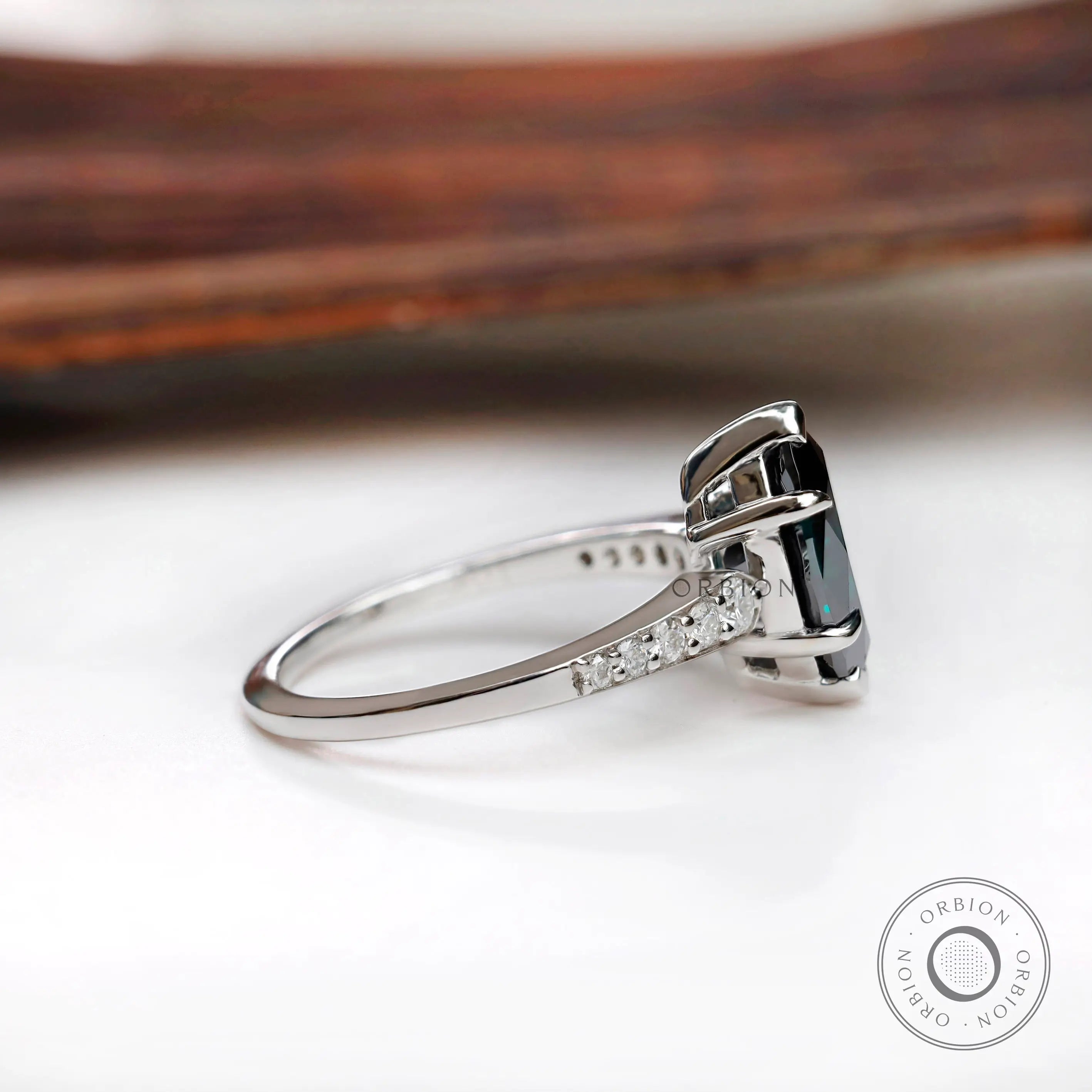Side profile of deep green marquise moissanite ring with tapered white gold band