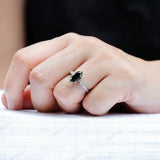 Marquise green moissanite engagement ring on finger close up