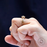 Bezel set solitaire cushion cut dark champagne moissanite ring worn on the finger