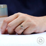 Solitaire cushion cut dark champagne moissanite engagement ring worn on hand