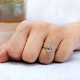 Close-up of Moissanite Light Champagne Old Mine Cut bezel set solitaire ring in 10K yellow gold worn on hand