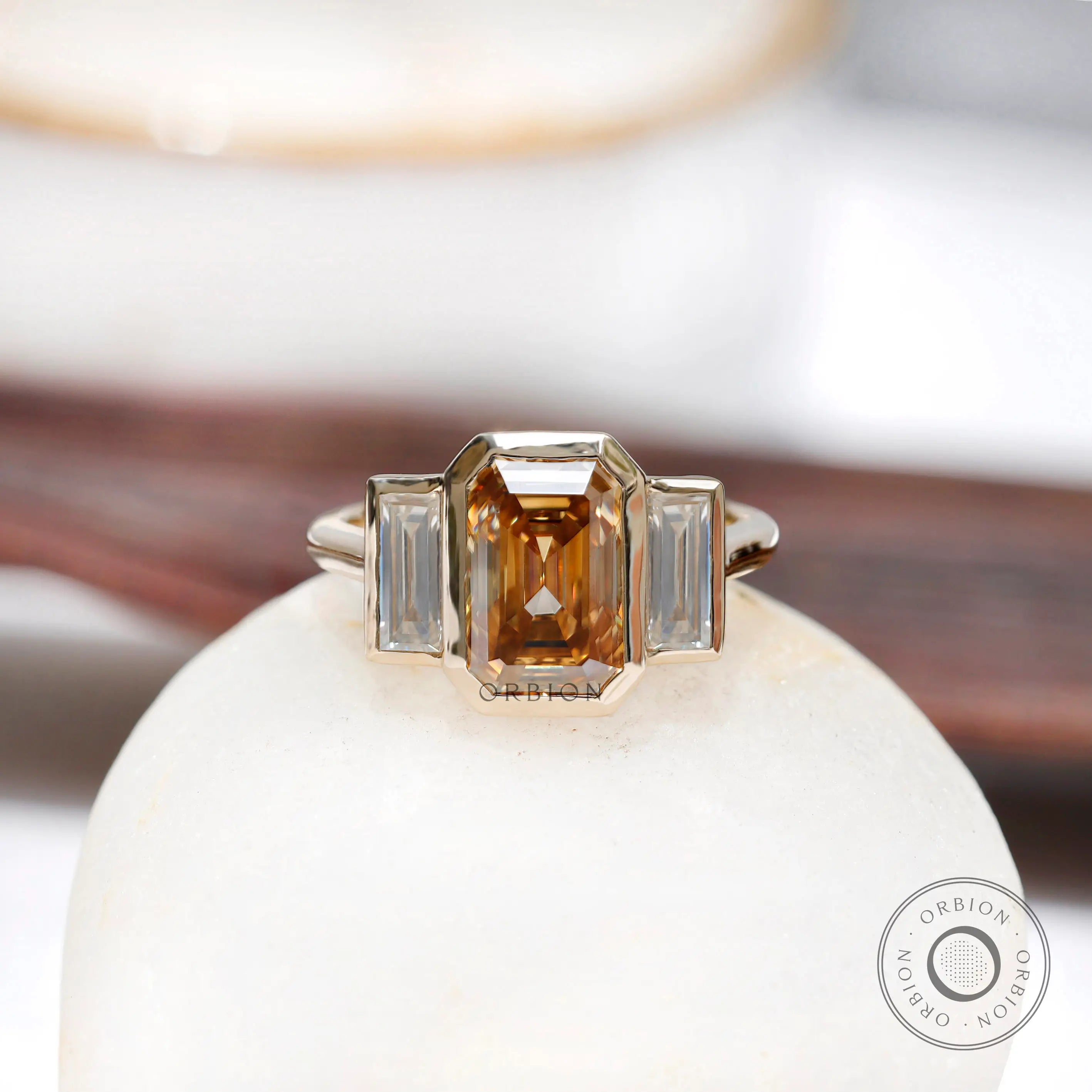 Dark champagne emerald cut moissanite three stone bezel set ring in 14K yellow gold