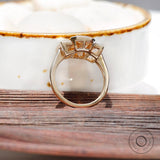 Bezel set emerald cut moissanite ring with step cut baguettes