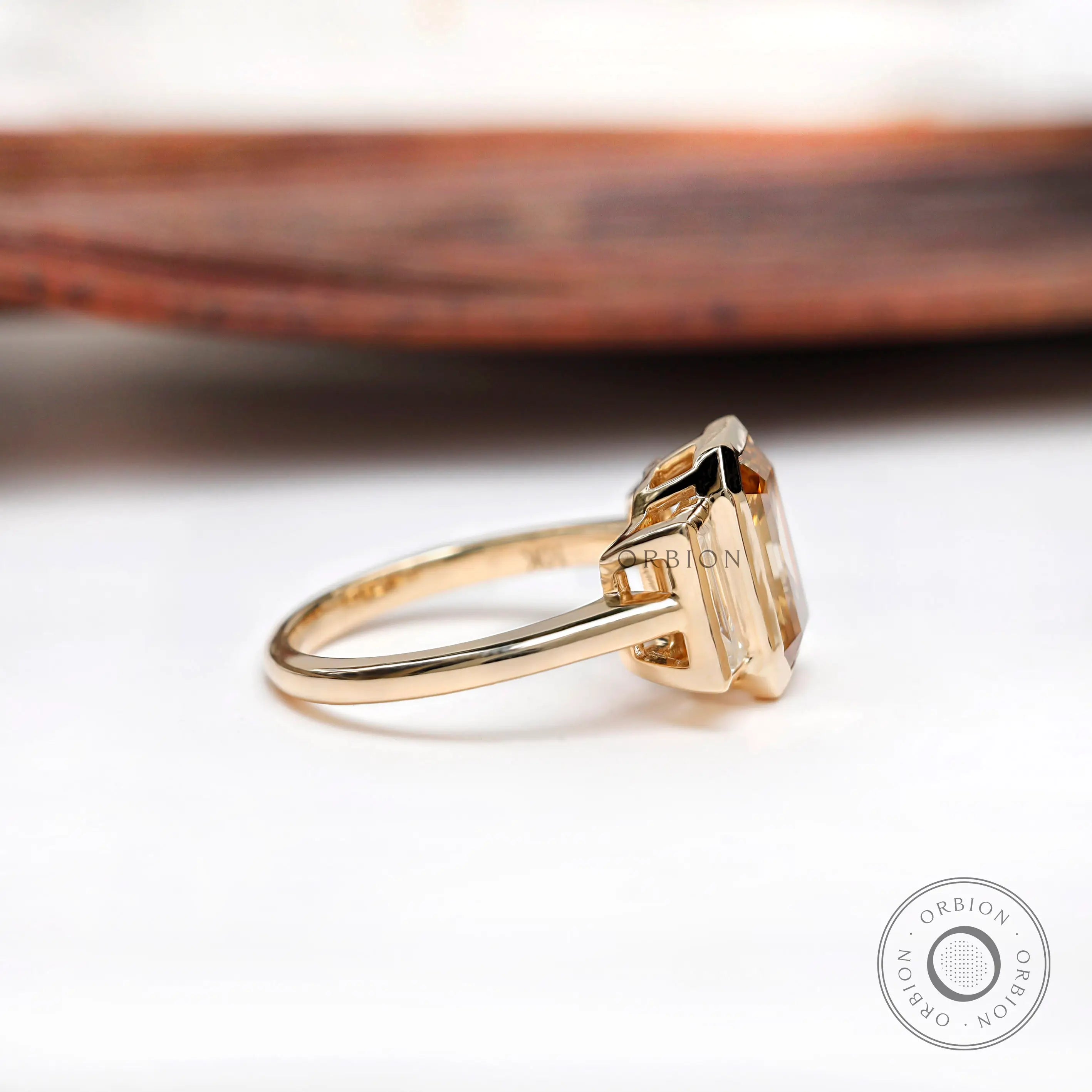 Three stone engagement ring with dark champagne center stone