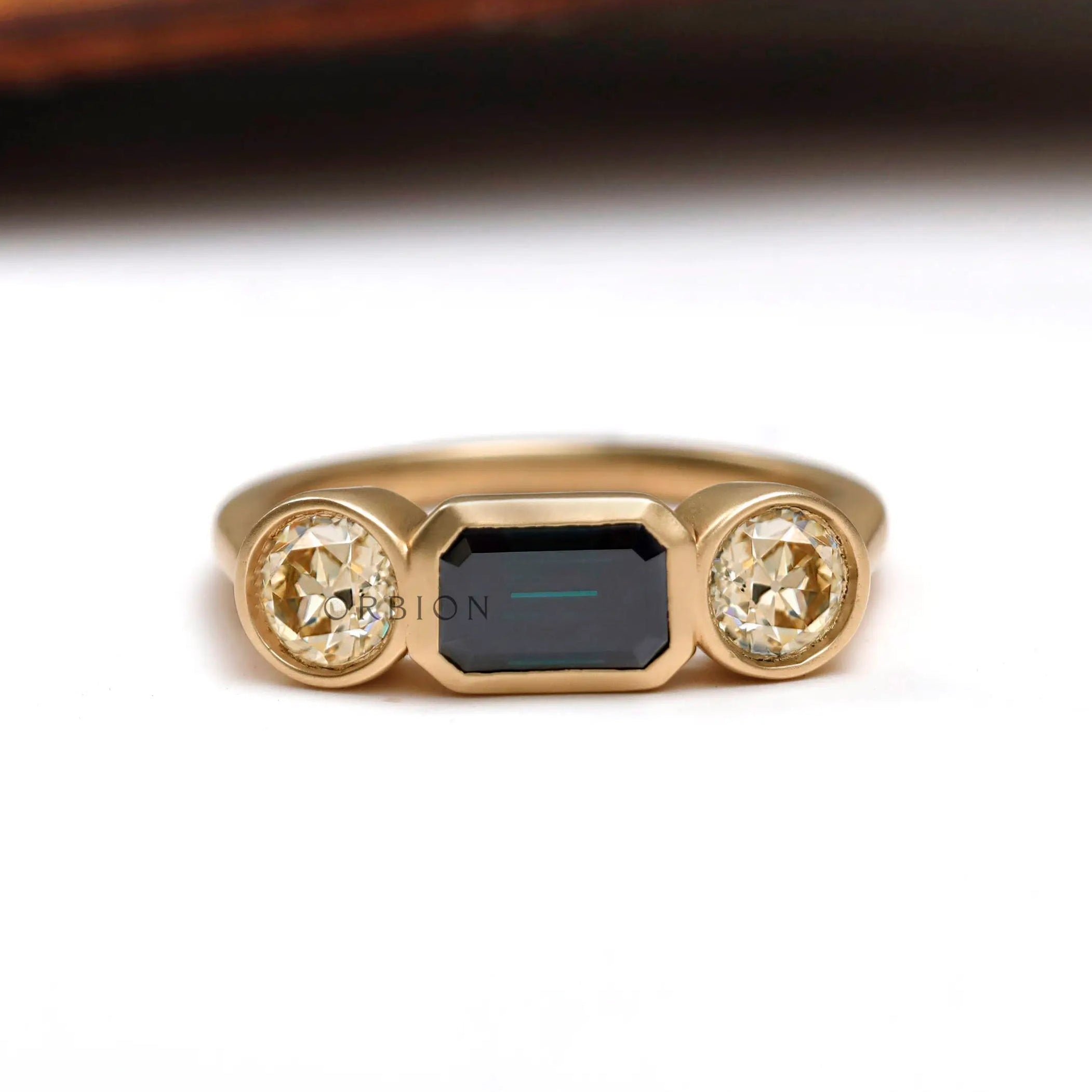 East west emerald cut green moissanite trilogy engagement ring in 14K yellow gold