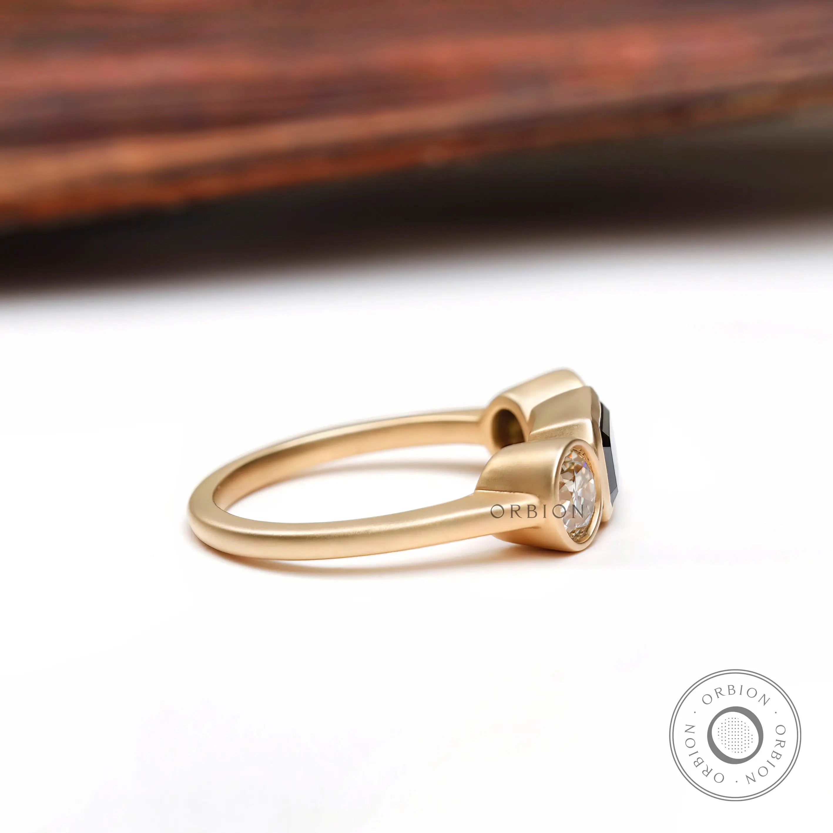 Matte finish yellow gold bezel set 3 stone engagement ring