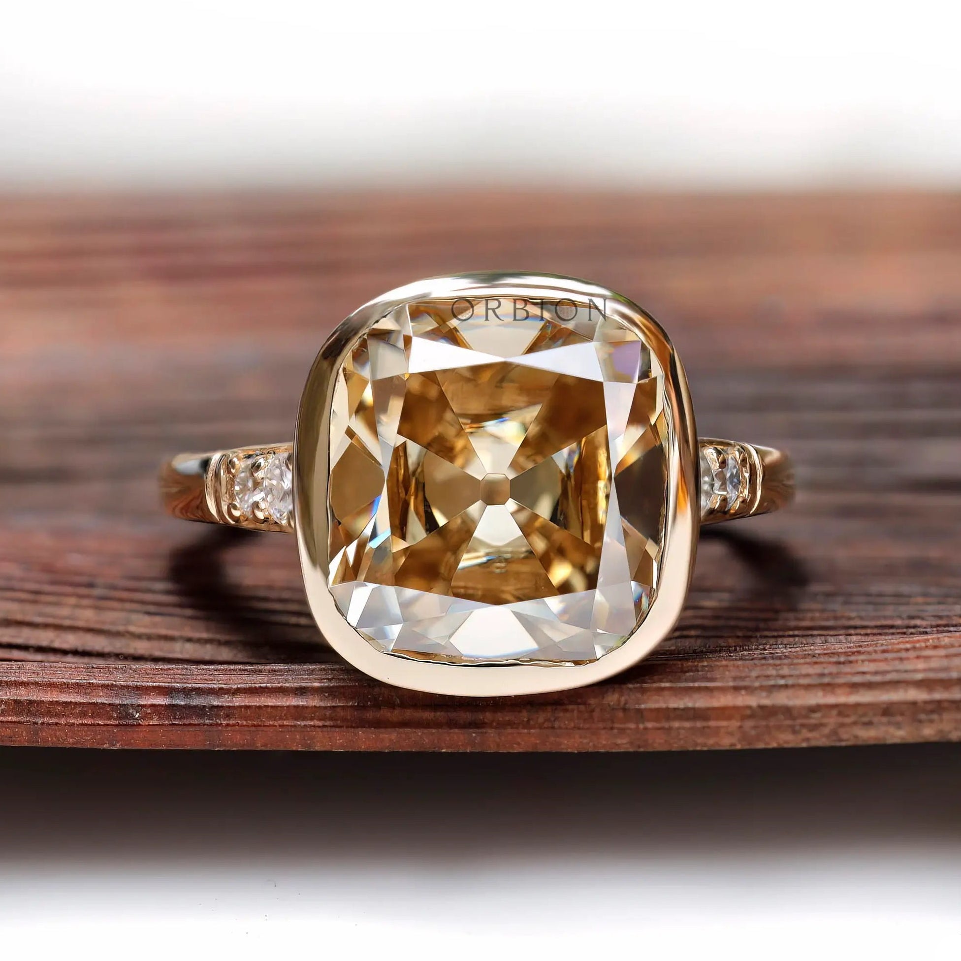 Front view of cushion-shaped Dark Champagne ring with bezel in yellow gold.