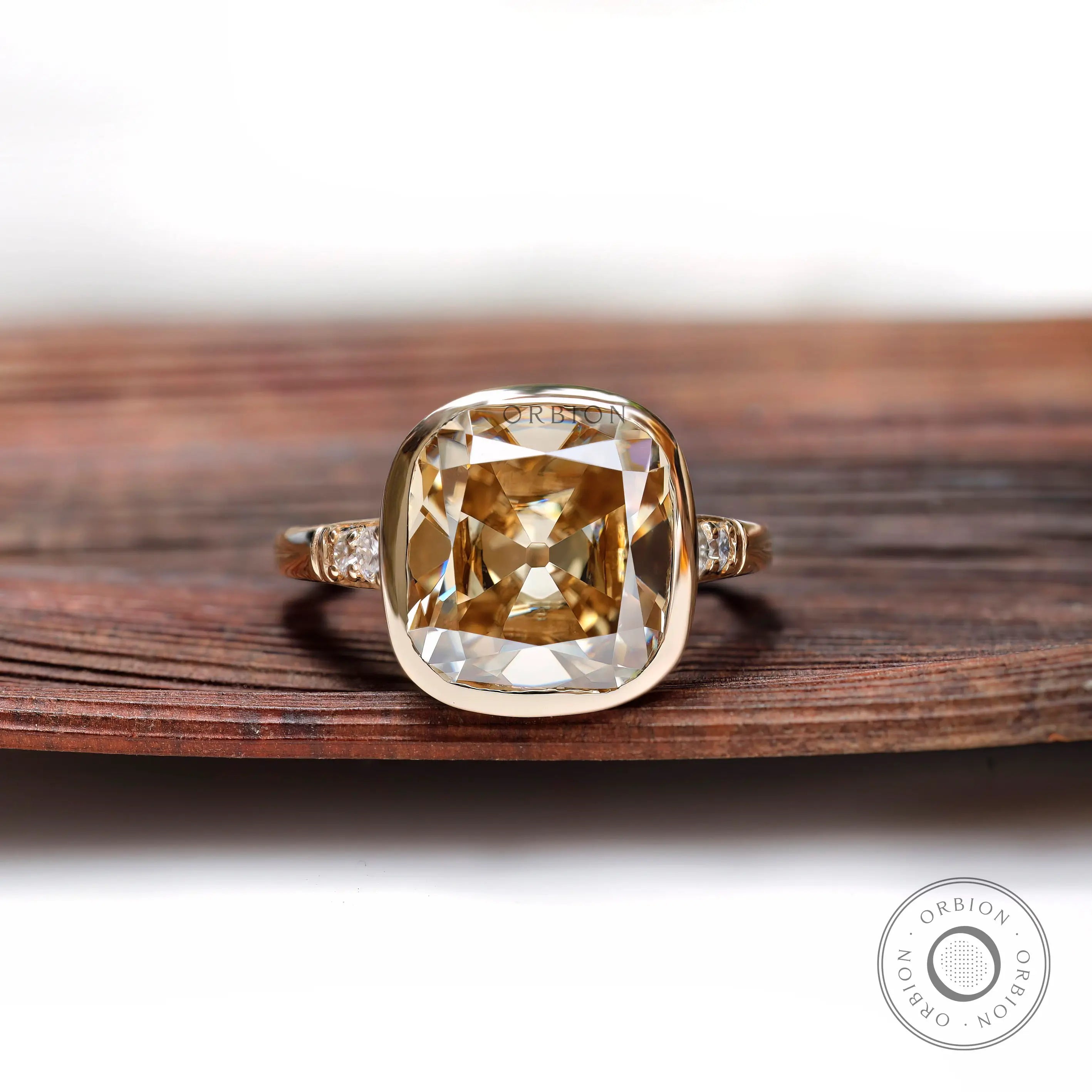 Front view of cushion-shaped Dark Champagne ring with bezel in yellow gold.