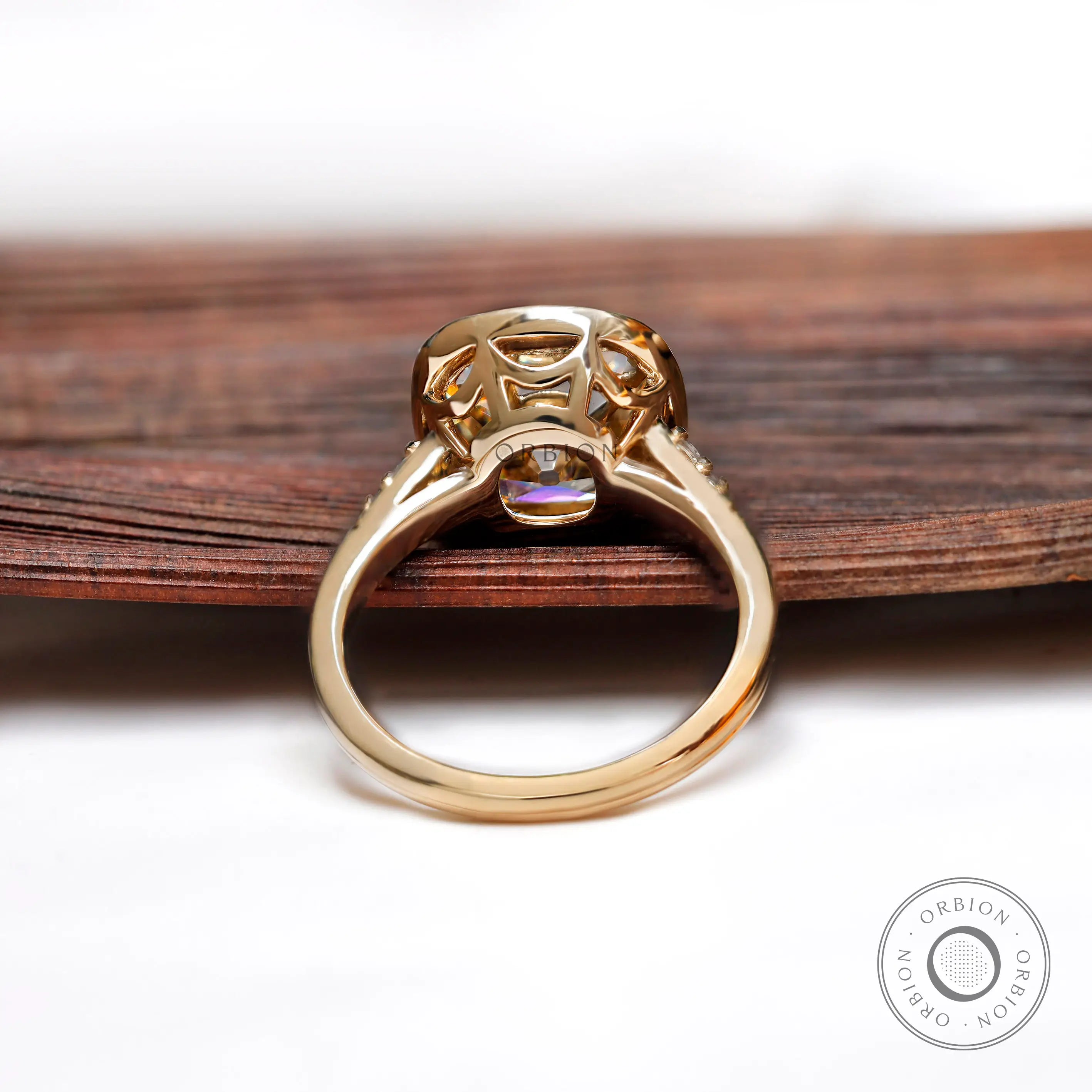 Back view of elongated cushion Moissanite ring with side set in yellow gold.