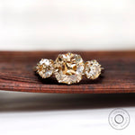 Light champagne three stone moissanite ring with cushion center top view