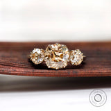 Light champagne three stone moissanite ring with cushion center top view