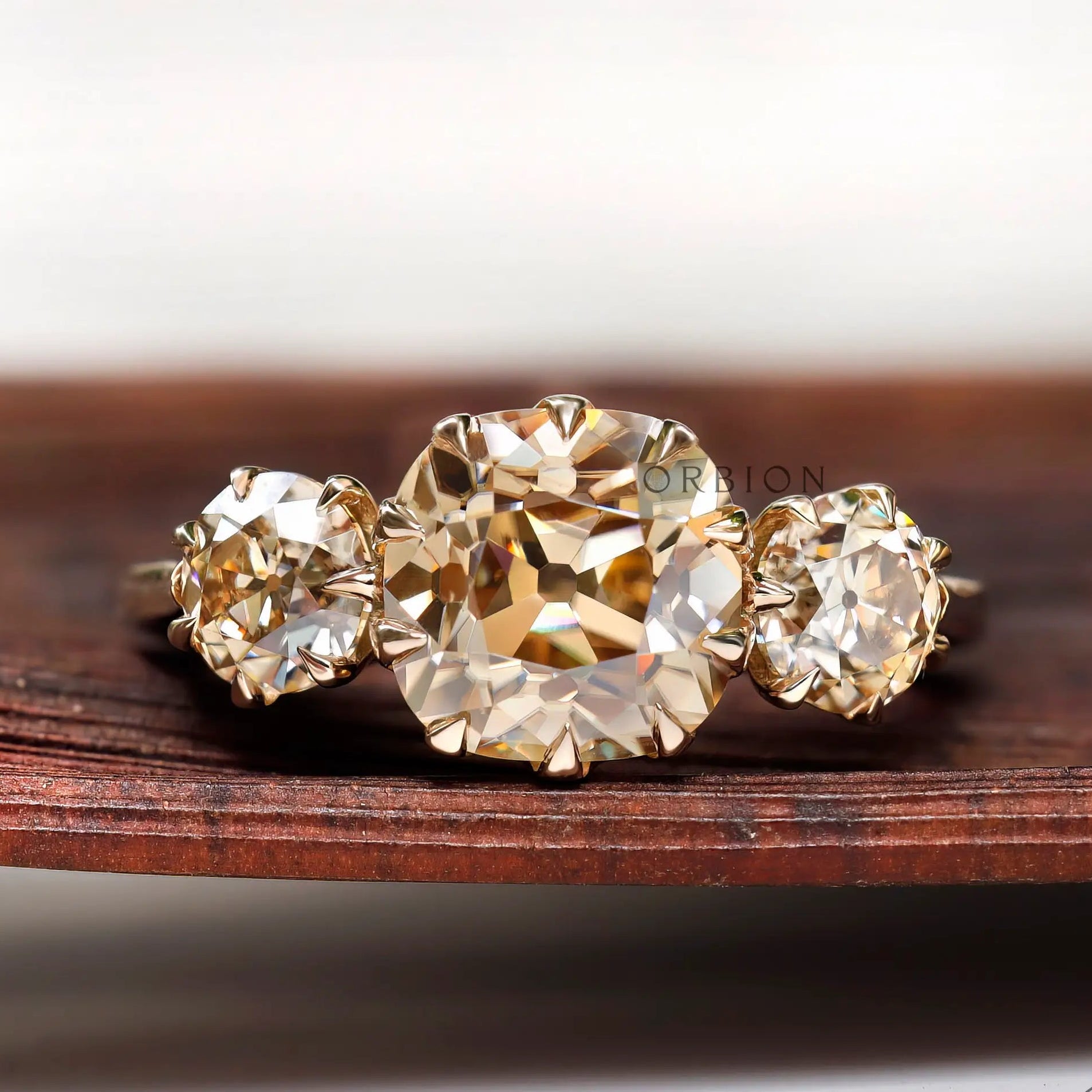 Light champagne three stone moissanite ring with cushion center top view
