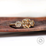 Angled view of three stone ring with Old Mine cut center and round sides