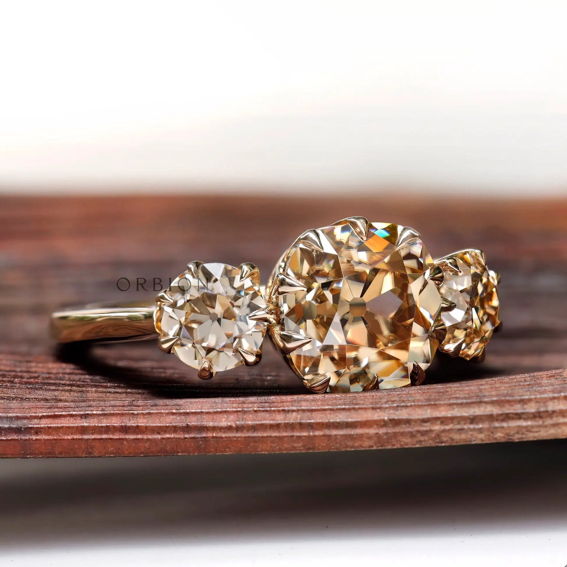Angled view of three stone ring with Old Mine cut center and round sides