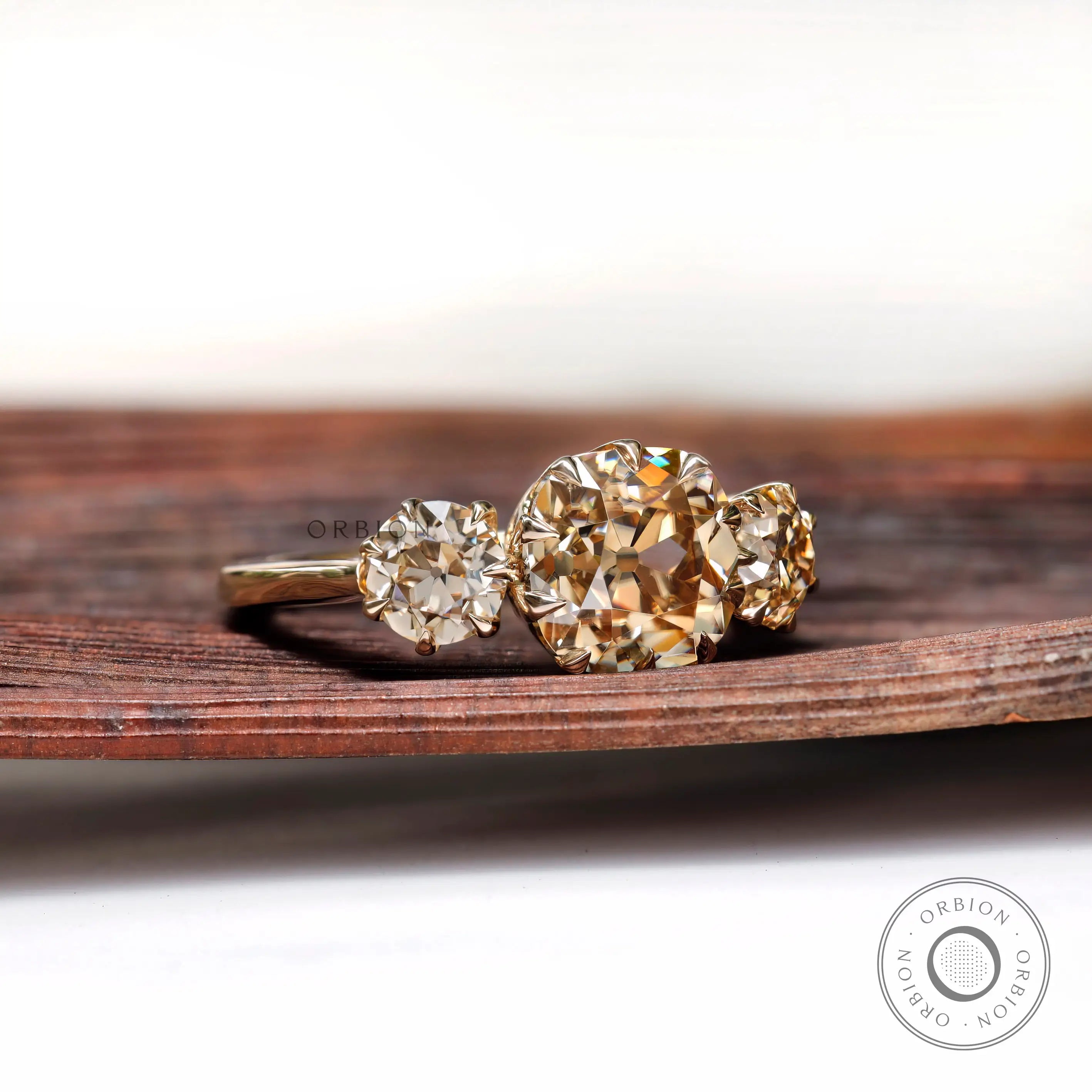 Angled view of three stone ring with Old Mine cut center and round sides