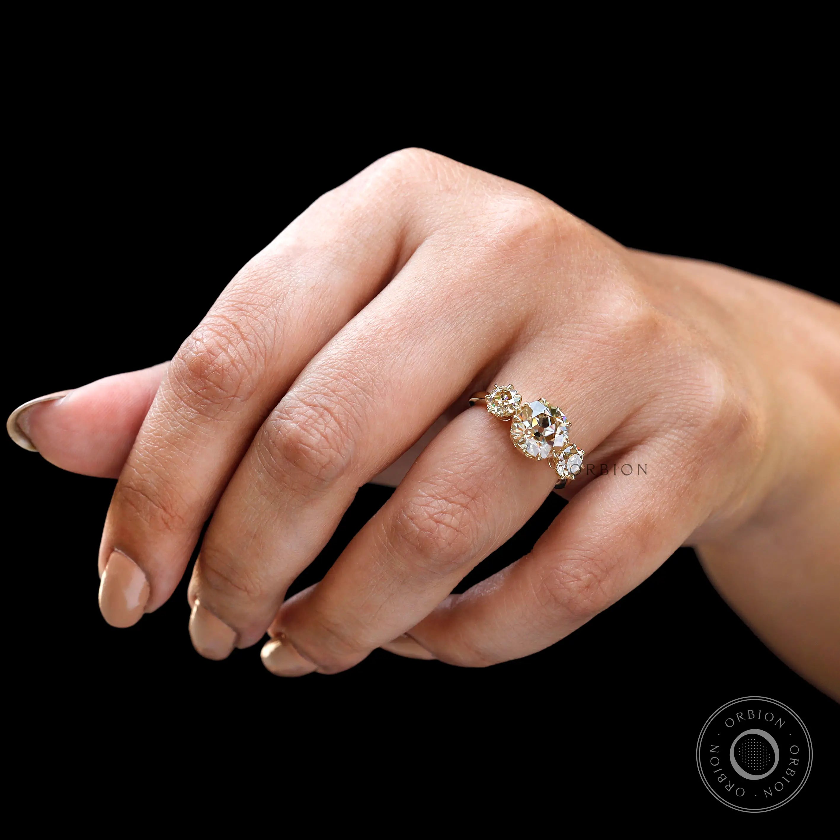 Hand worn three stone moissanite ring front perspective
