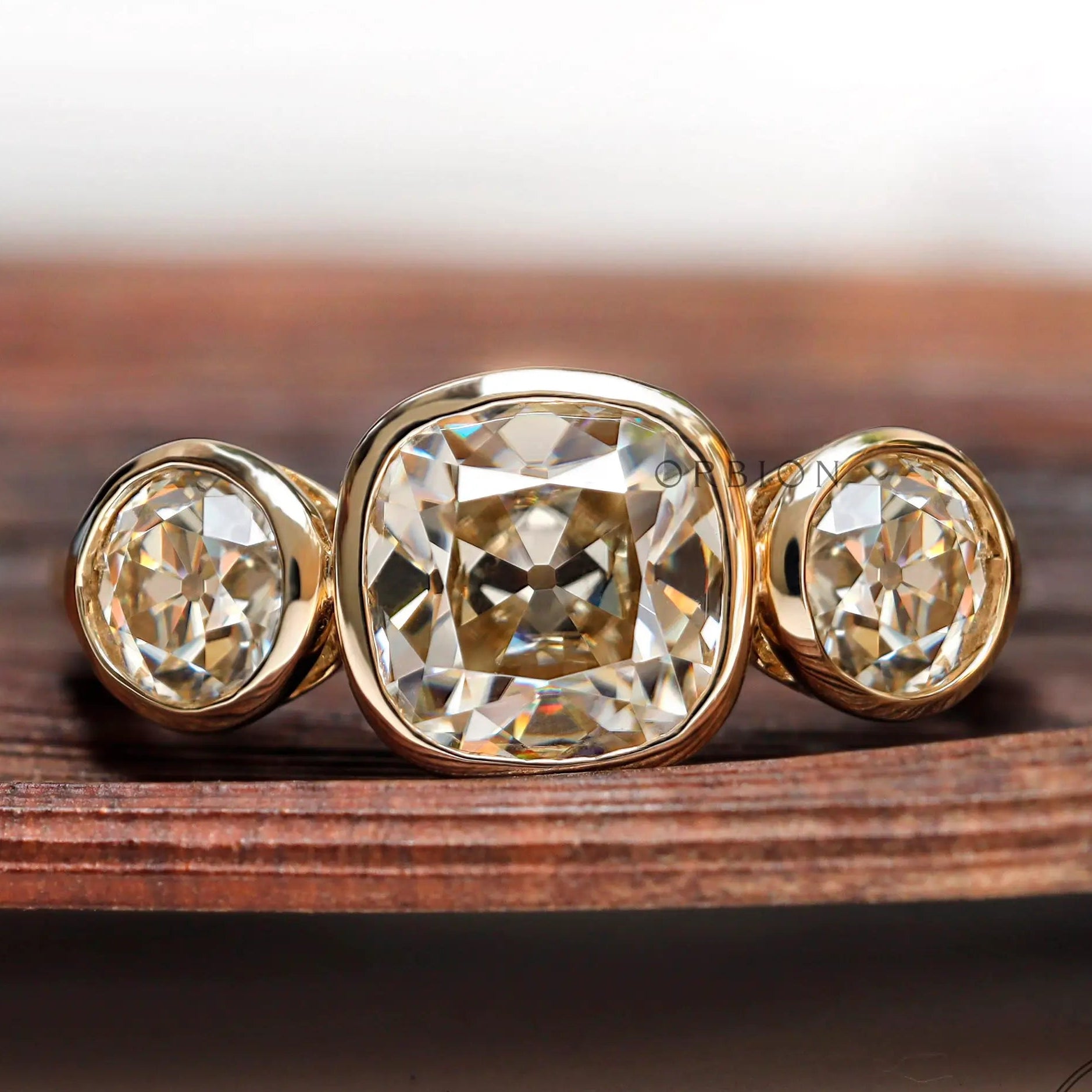 Three stone cushion moissanite ring in 10K yellow gold front view