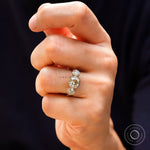 Hand model wearing champagne cushion three stone ring