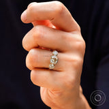 Hand model wearing champagne cushion three stone ring
