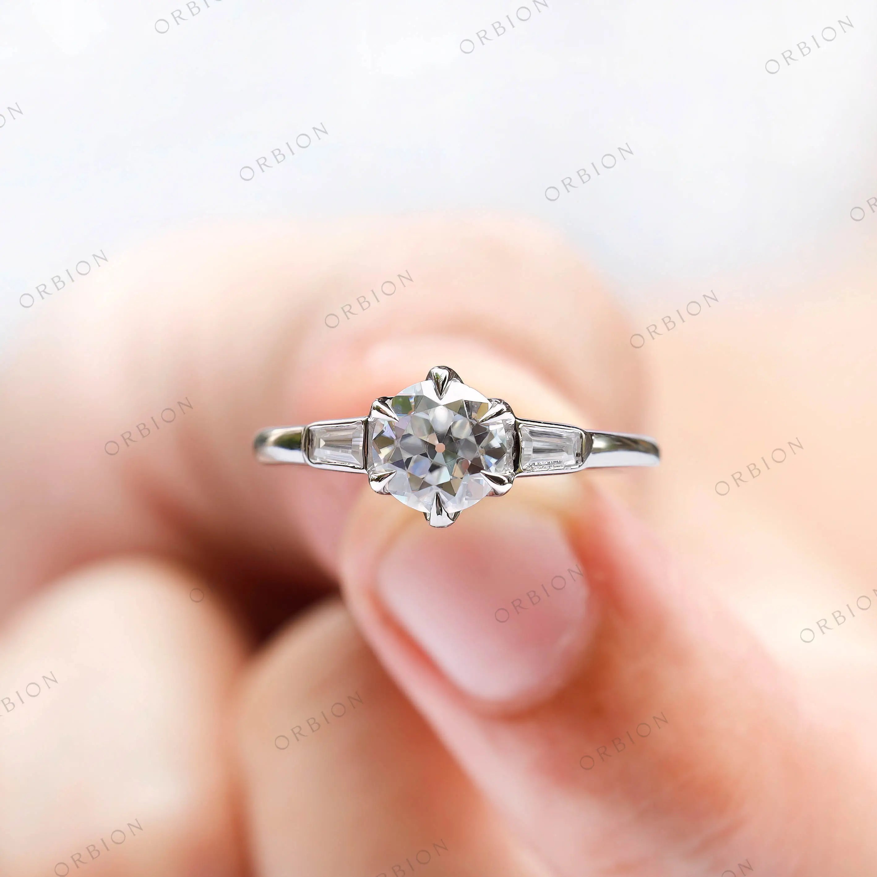Minimal trilogy vintage engagement ring with step cut side stones  