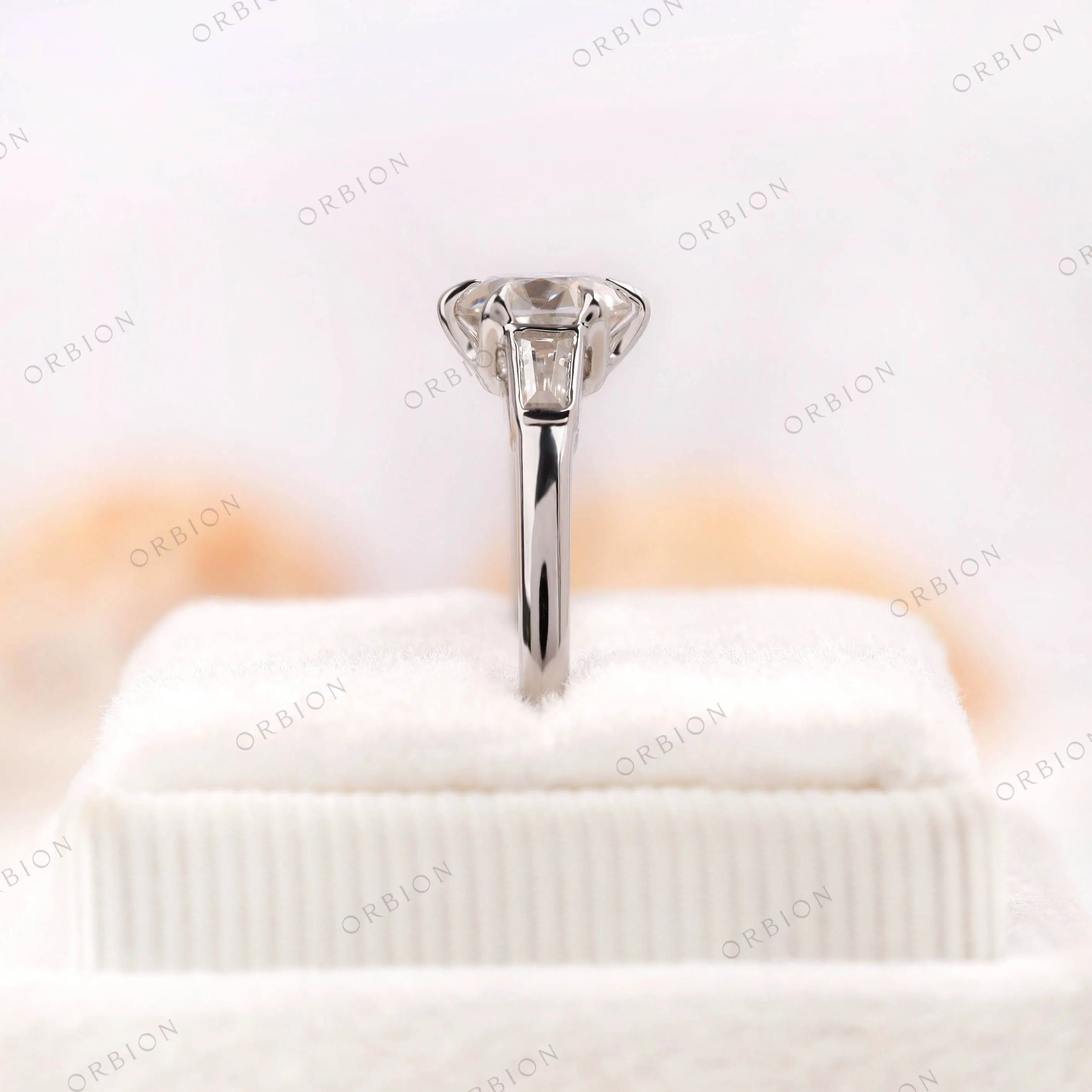Vintage inspired engagement ring on finger with baguette side stones