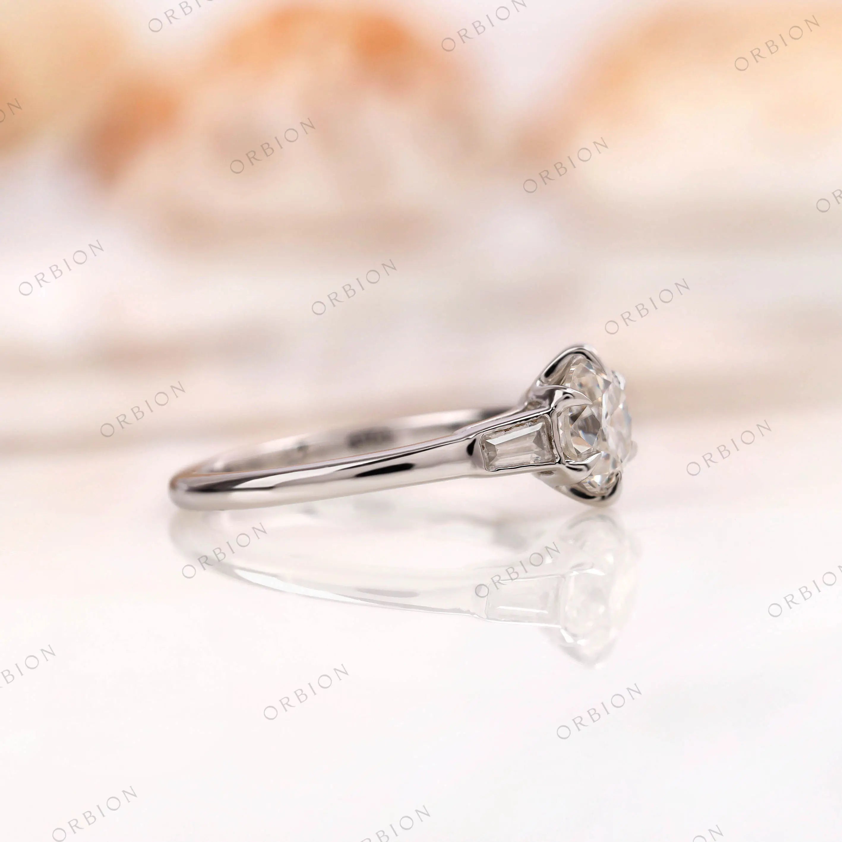 Side profile of three stone engagement ring in white gold 