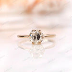 Solitaire moissanite engagement ring with round Old European cut center stone in 10K yellow gold.