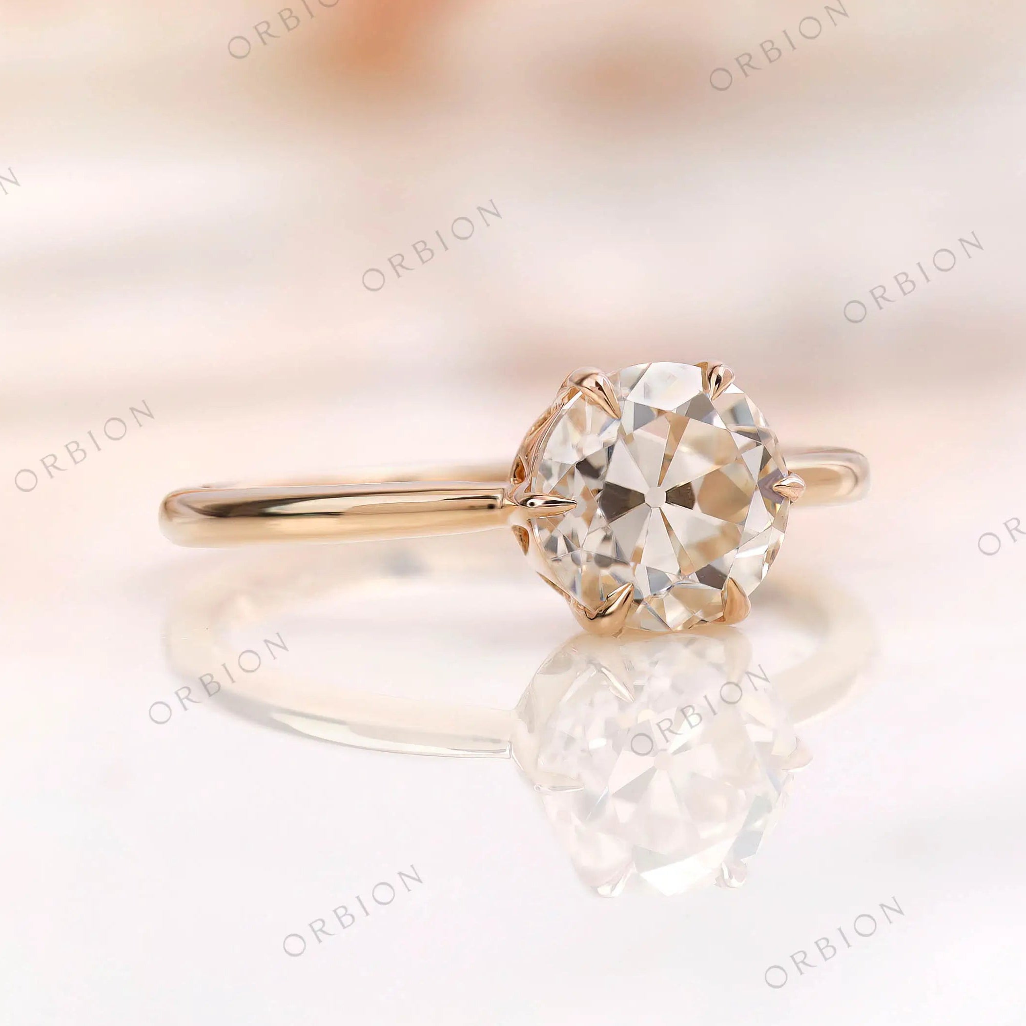 Solitaire engagement ring showcasing the round moissanite center stone in 10K yellow gold.