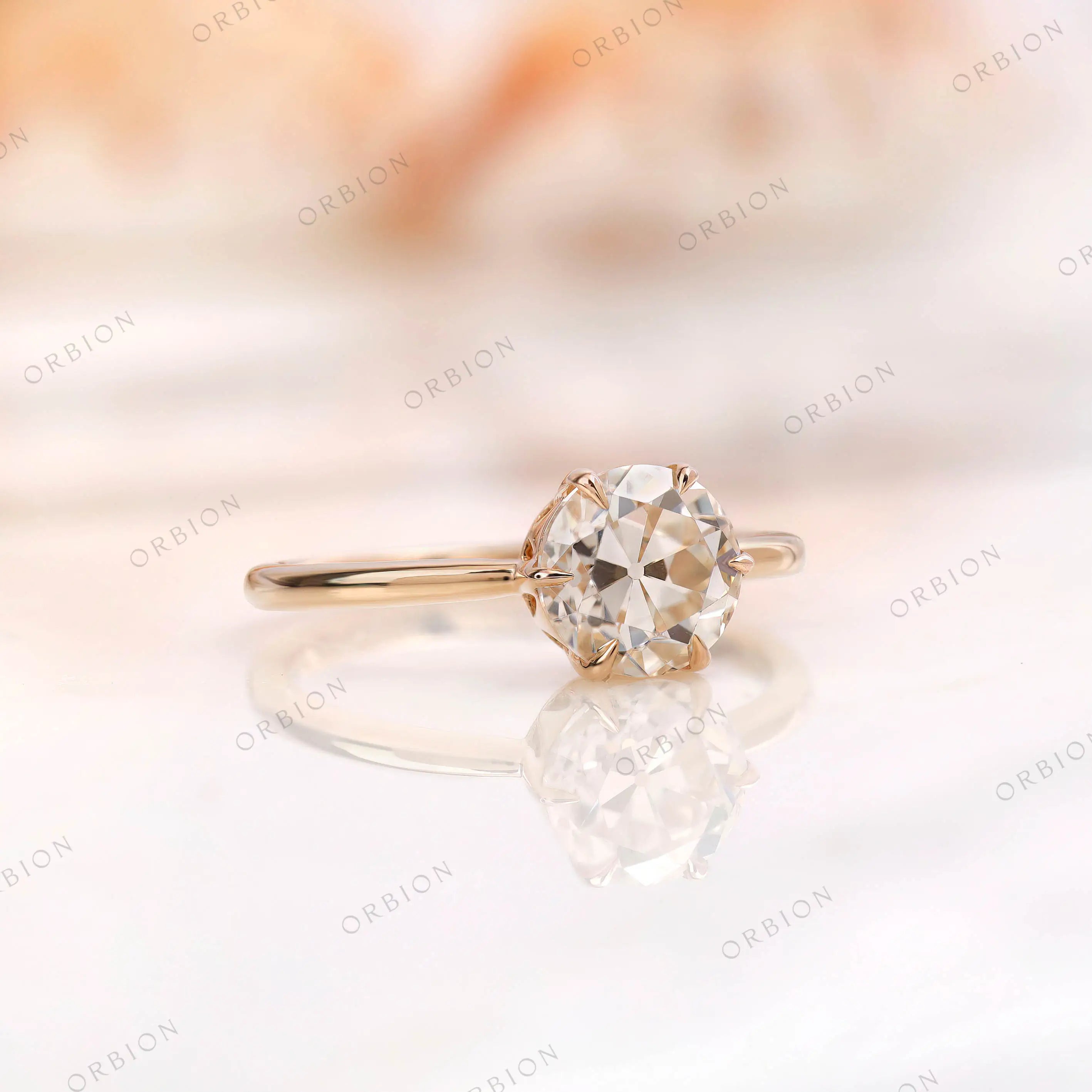 Solitaire engagement ring showcasing the round moissanite center stone in 10K yellow gold.