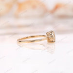 Close-up of the solitaire moissanite engagement ring, highlighting the Old European cut and yellow gold setting.