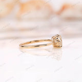 Close-up of the solitaire moissanite engagement ring, highlighting the Old European cut and yellow gold setting.
