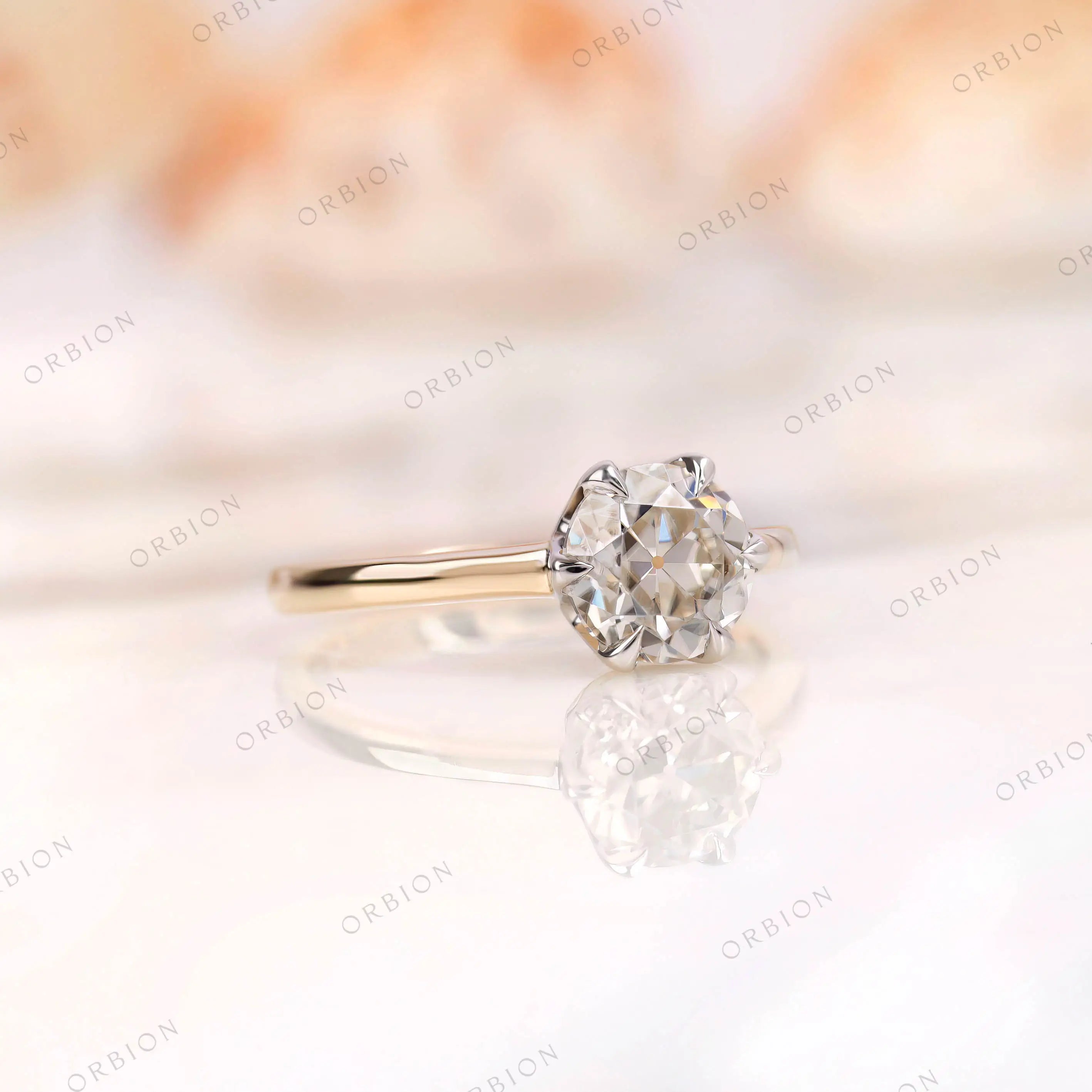 Side angle view of the Old European Cut Moissanite solitaire ring, focusing on the bezel setting and band in dual-tone 10K gold.