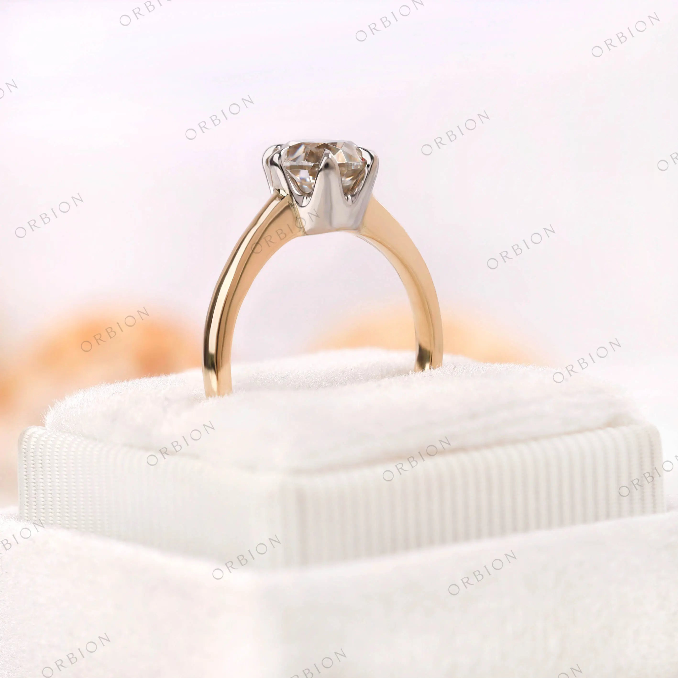 Old European Cut Round Moissanite solitaire ring displayed on a velvet cushion, showing off the stone’s brilliance and the 10K yellow-white gold setting.