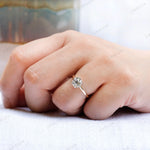 Close-up shot of the ring on a finger, showcasing the elegant bezel setting and the dual-tone 10K gold band.