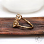 Side profile of toi et moi moissanite ring in yellow gold