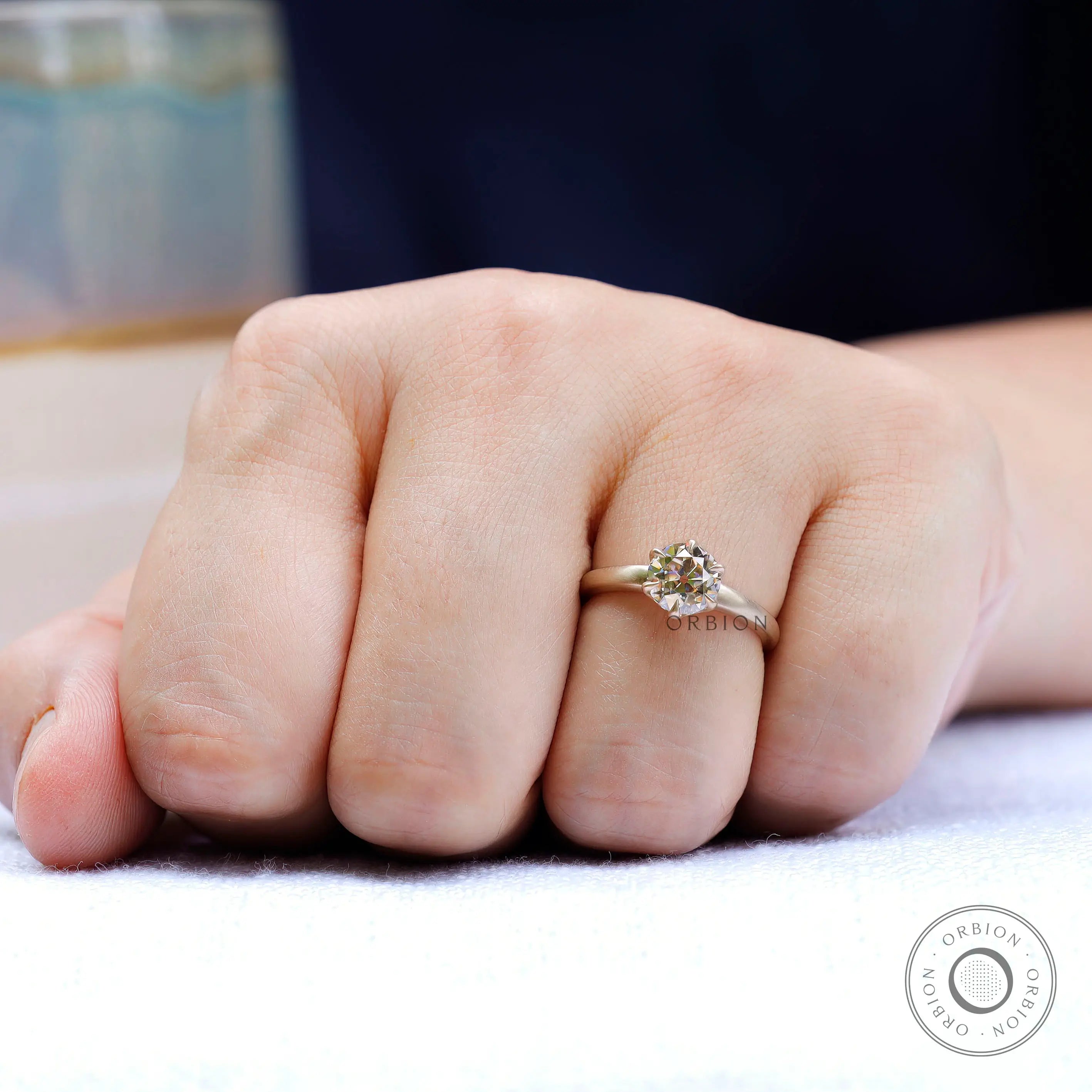 Yellow gold moissanite solitaire ring worn on hand