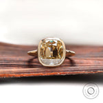 Front view of elongated cushion champagne moissanite bezel engagement ring