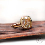 Elongated cushion light champagne moissanite bezel solitaire ring in yellow gold