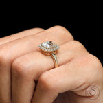 Vintage inspired cushion halo ring with diamond accents on fingure