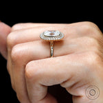 Yellow gold halo ring with round accent stones on fingure