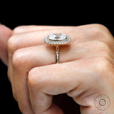 Yellow gold halo ring with round accent stones on fingure
